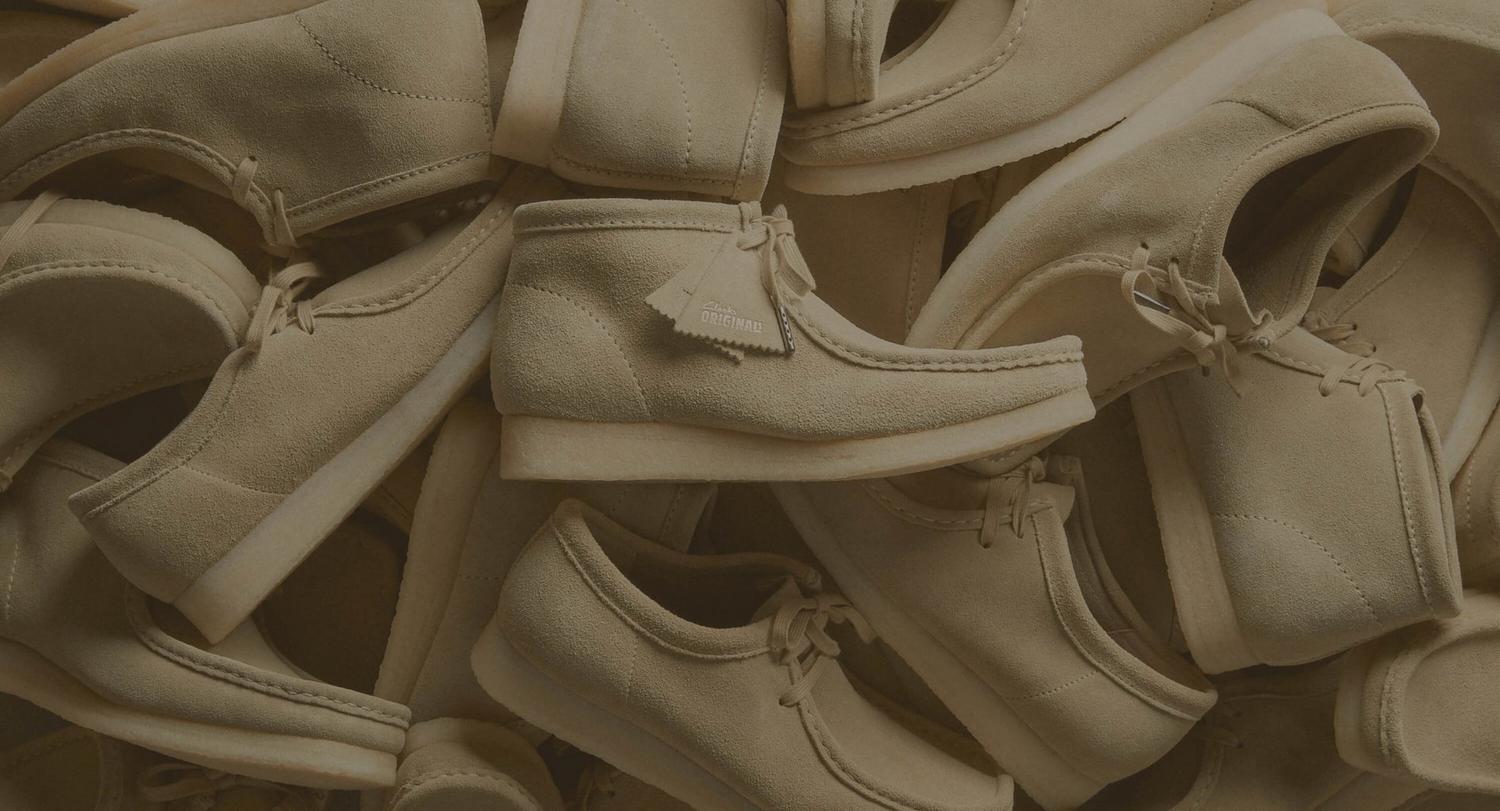 A pile of beige Clarks Originals Wallabee shoes
