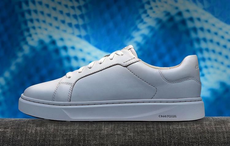 White Clarks Code trainer shown in profile against a blue patterned background