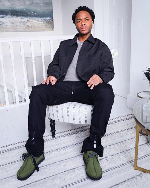 Raheem Sterling sat wearing the olive Trek Hi