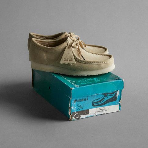 A pair of Clarks Wallabees positioned on a shoe box