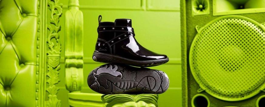 Black children's school boot against a bright green background