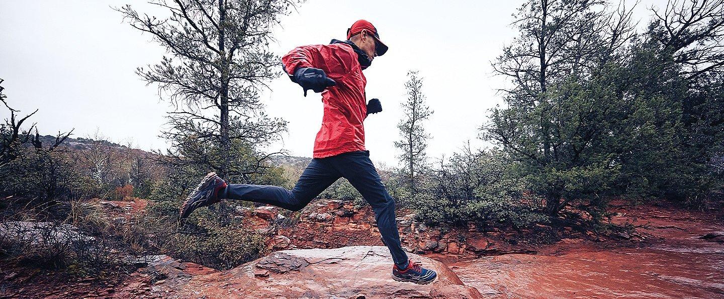 Man running on dirt trail.