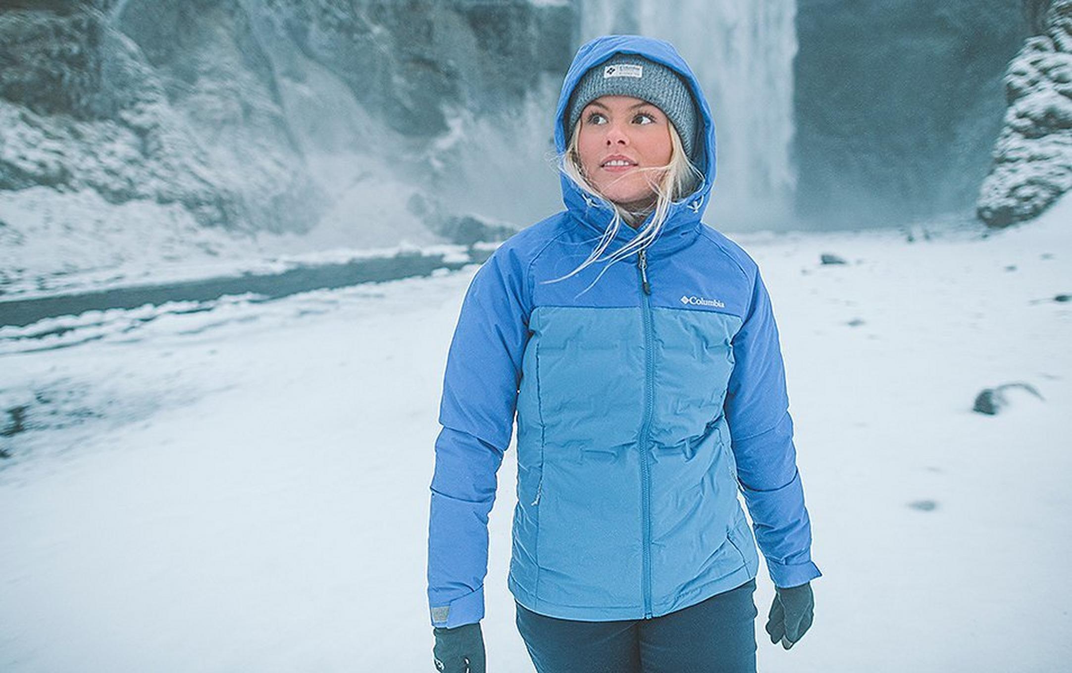 A woman wearing blue jacket in a snowy scene.
