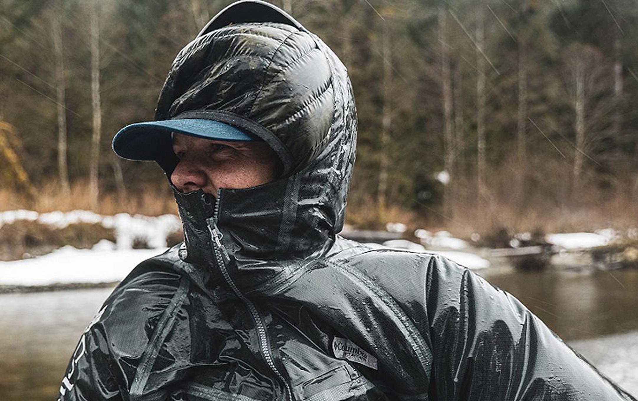 Pro angler Curtis Ciszek stands in front of a snowy river bank looking off in the distance.