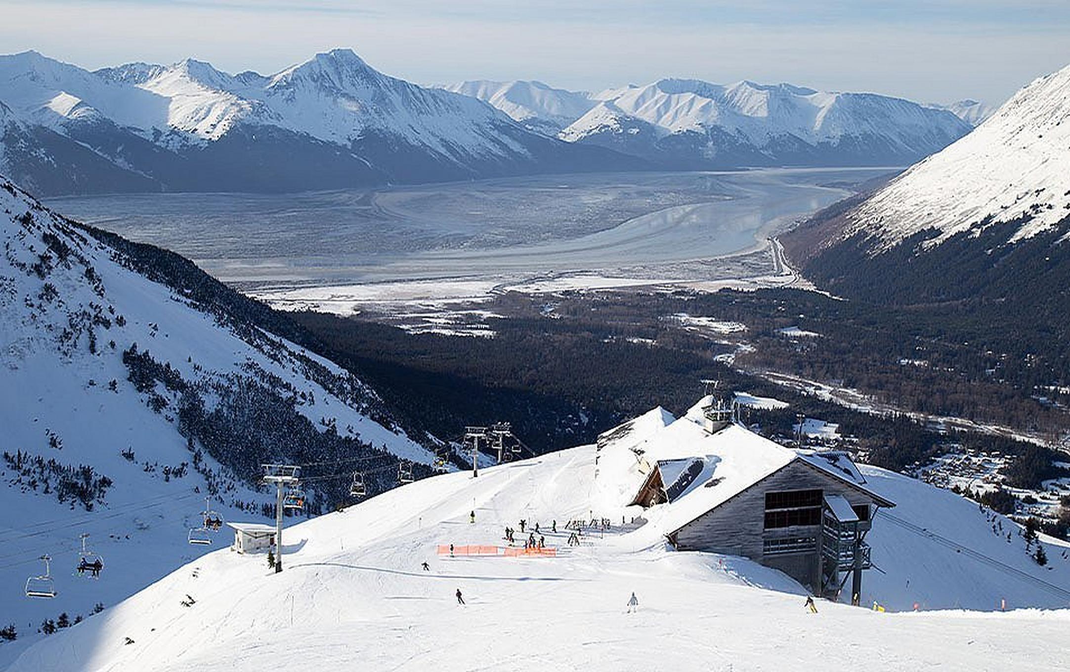 A beautiful landscape shot of Aleyeska Resort with a chairlift in the foreground and gorgeous mountains towering in the background.