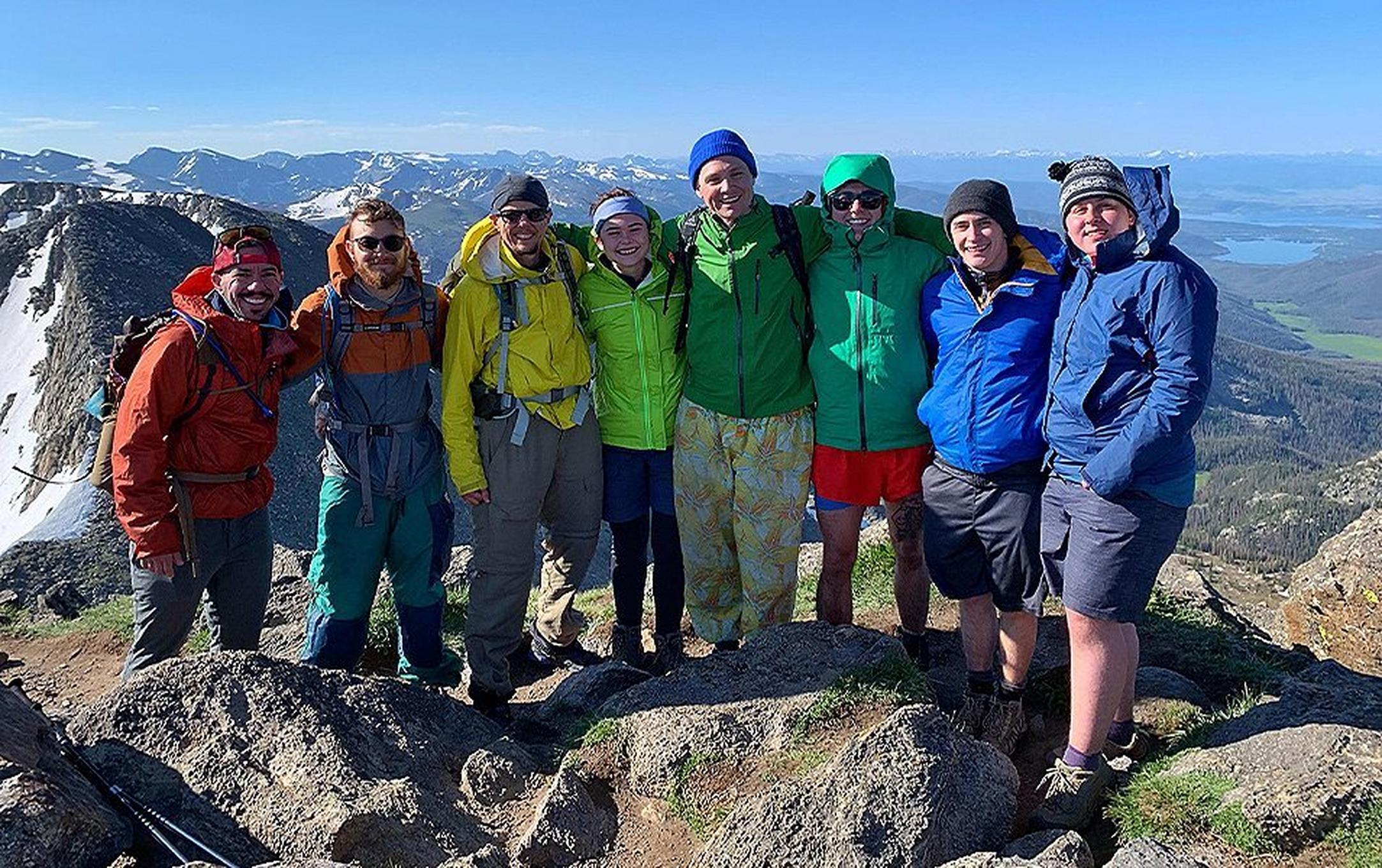 Group of hikers poising at the top of a mountain.