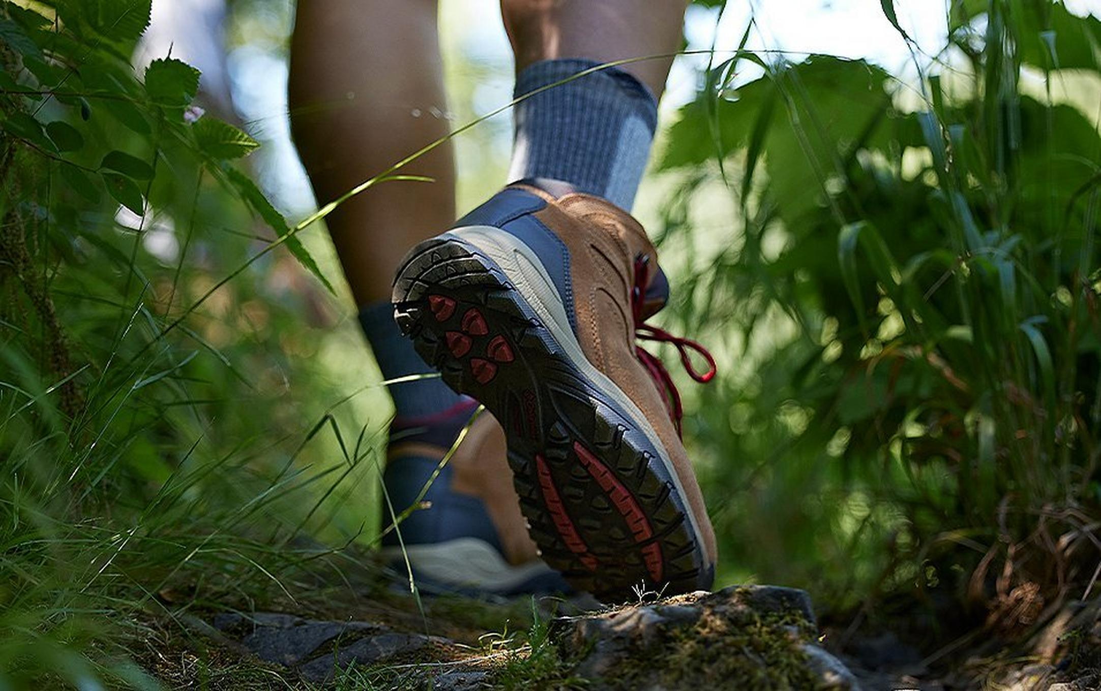 Legs of a hiker in Columbia Sportswear hiking boots walking through tall grass