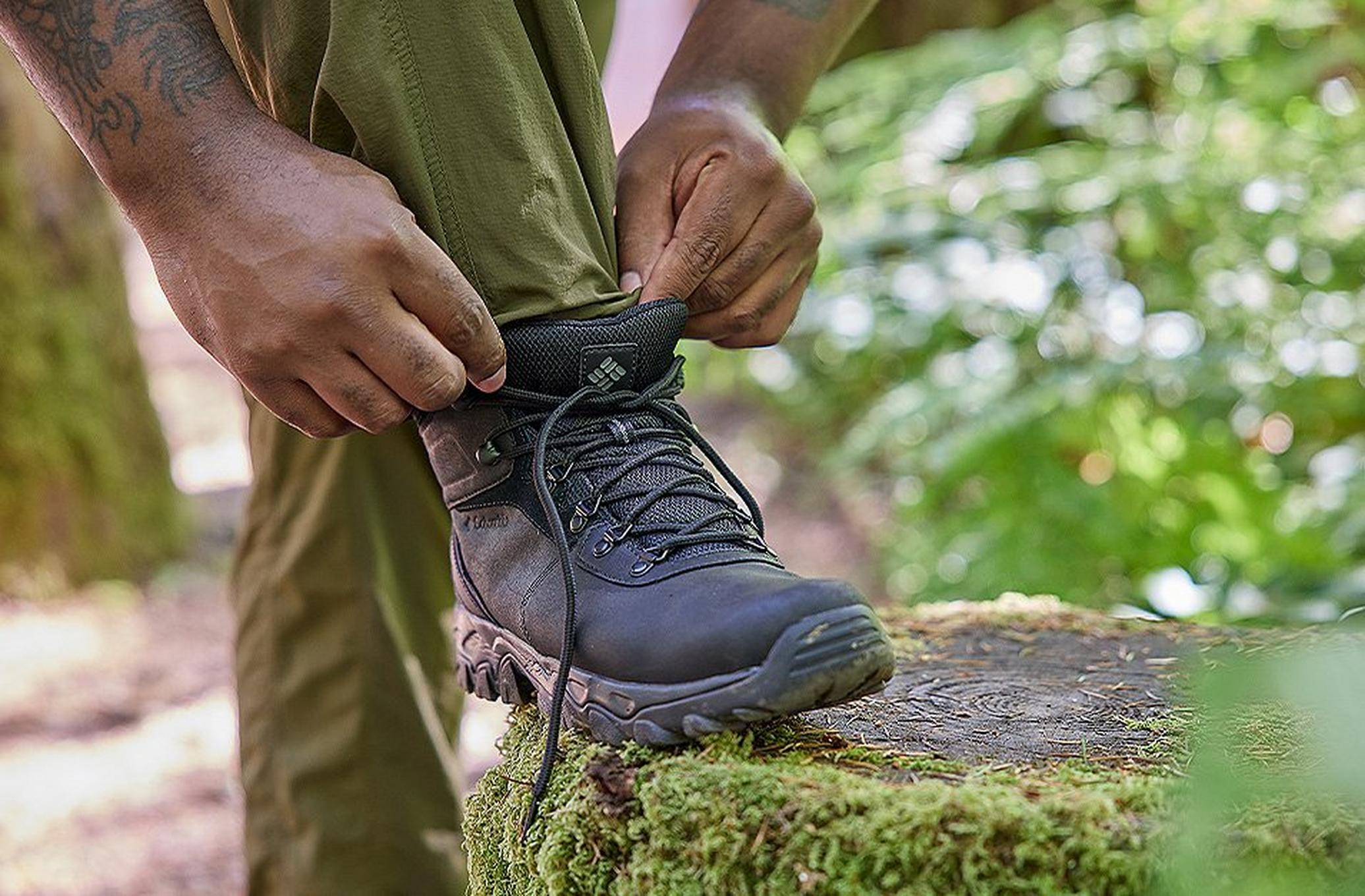 Legs of a hiker adjusting Columbia Sportswear Hiking boots.