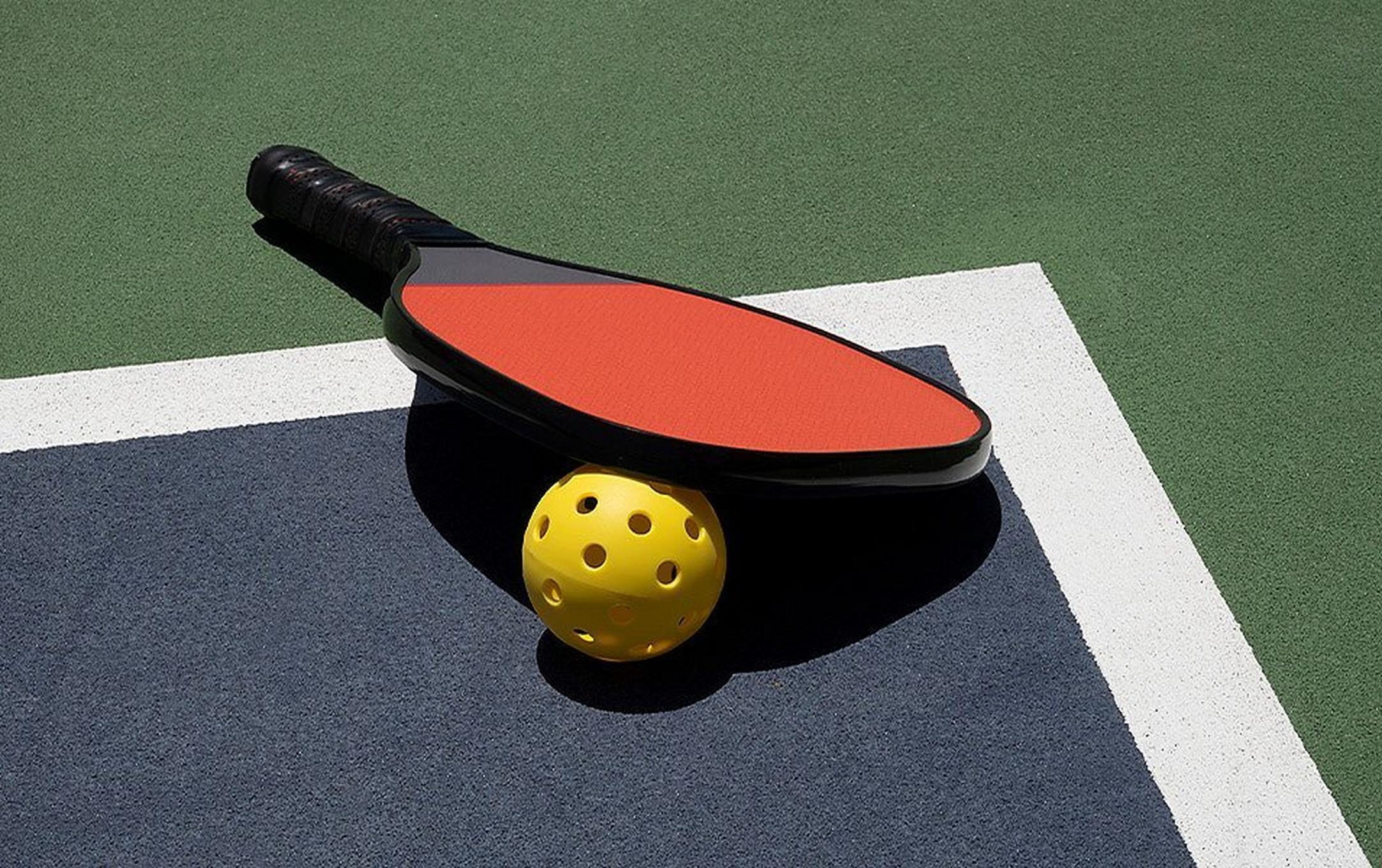 A pickleball racquet and ball.