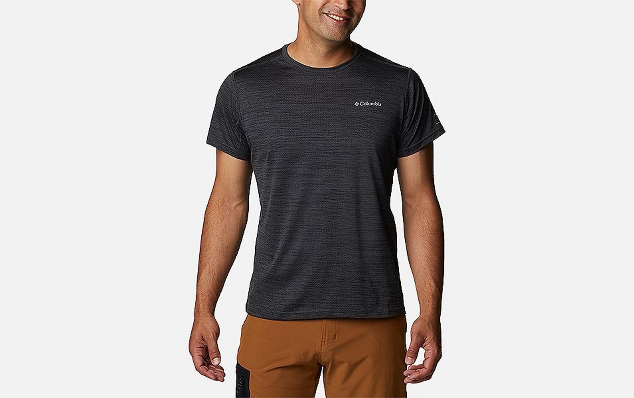 A product shot of a man wearing a Columbia Sportswear hiking shirt and brown pants set against a white background.
