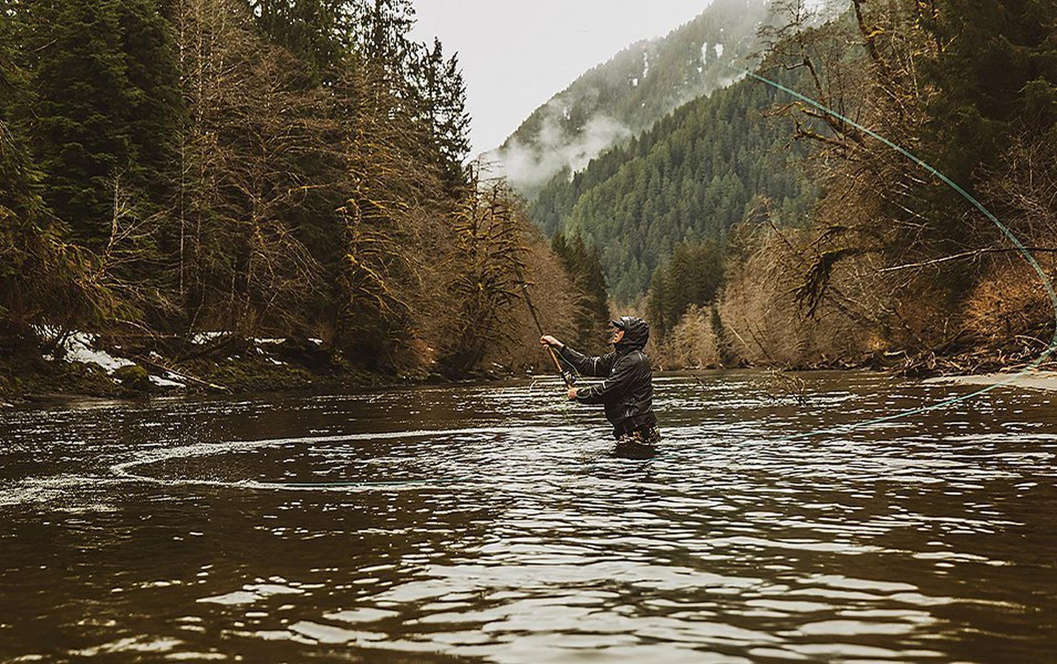 Curtis Ciszek fly fishing in on a river.