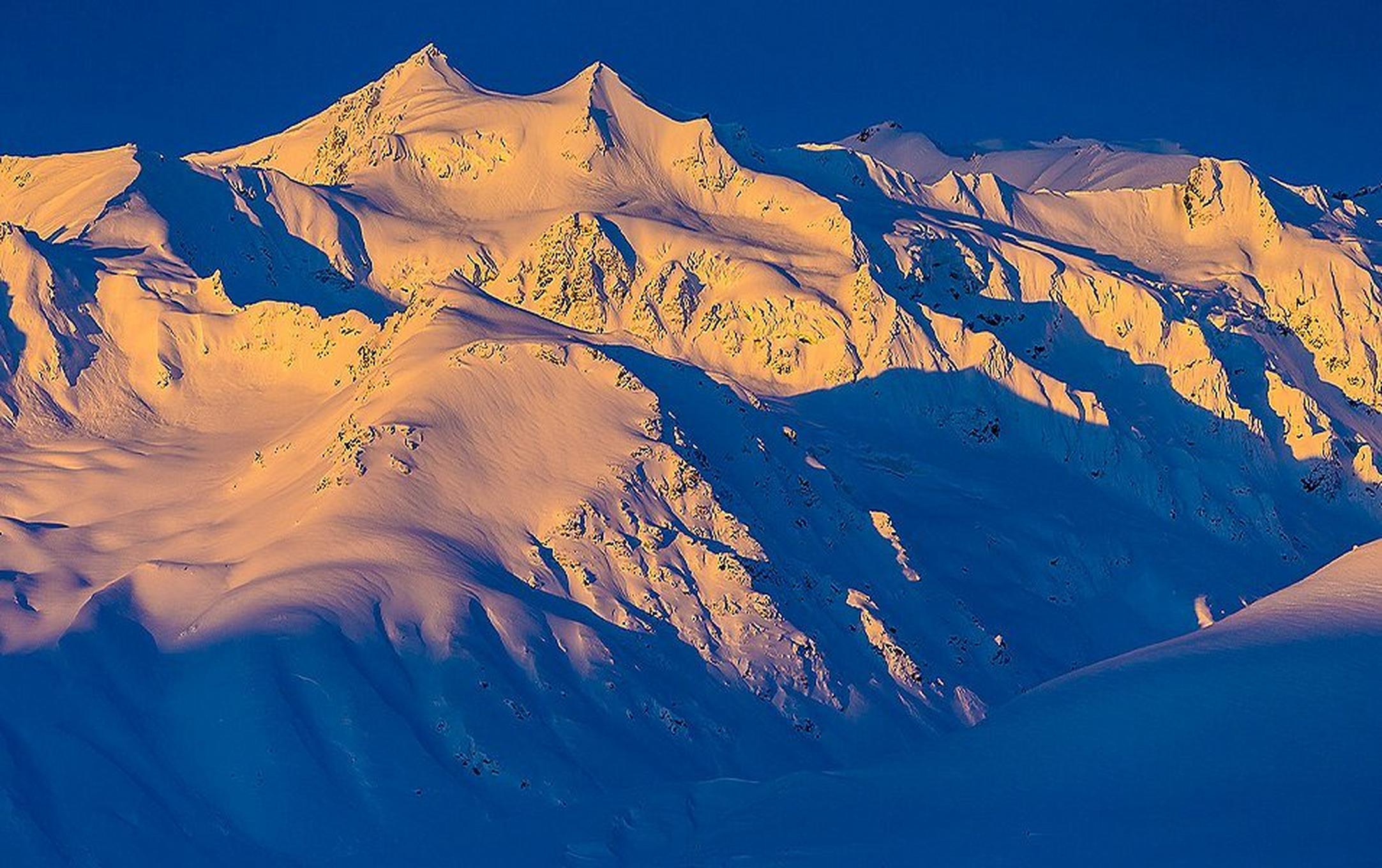 Snowy mountain landscape at sunset.