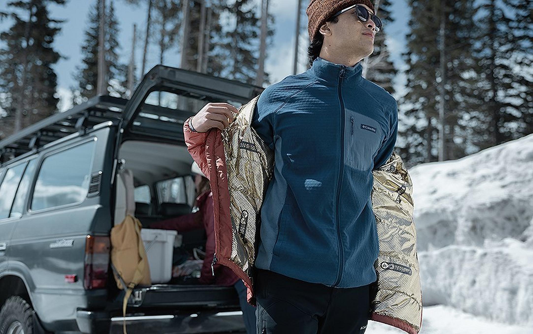 A man is pictured taking off an Omni-Heat Infinity jacket on a cold winter day.