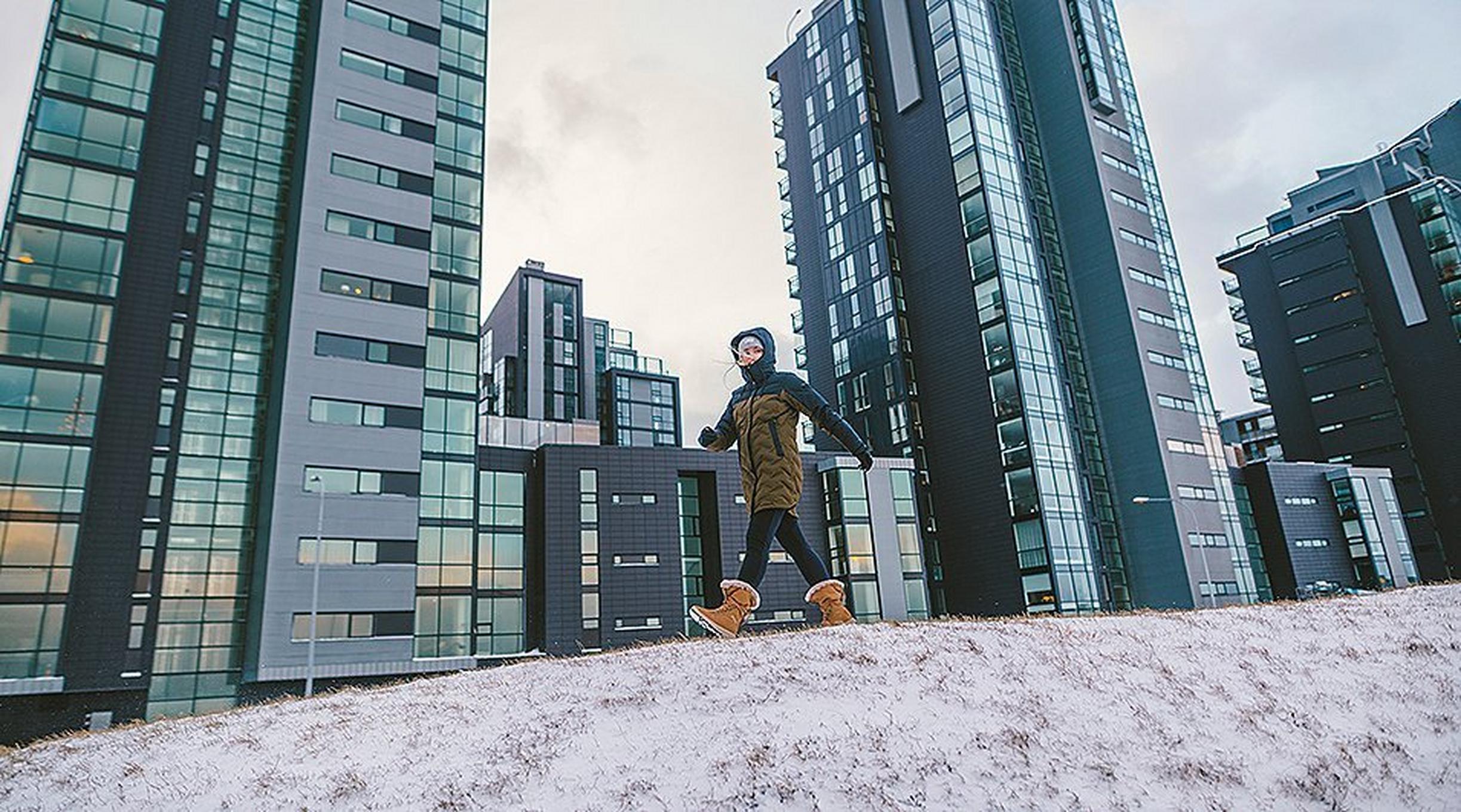 A woman walking through a snowy city in Columbia gear.