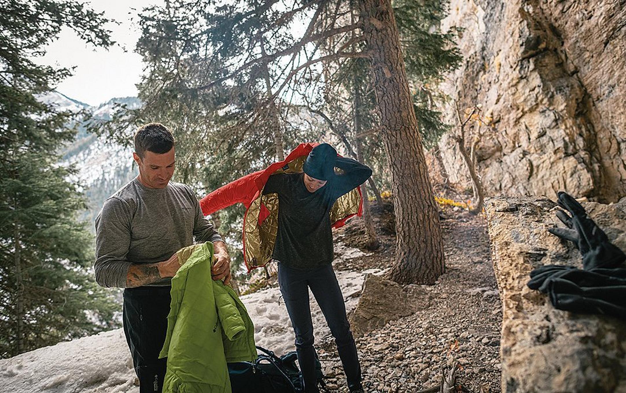 People putting on coats in a winter landscape.