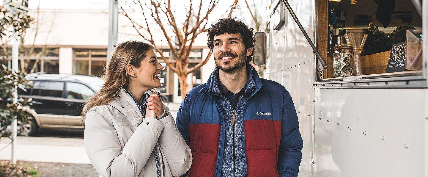 A man and woman at a food cart.