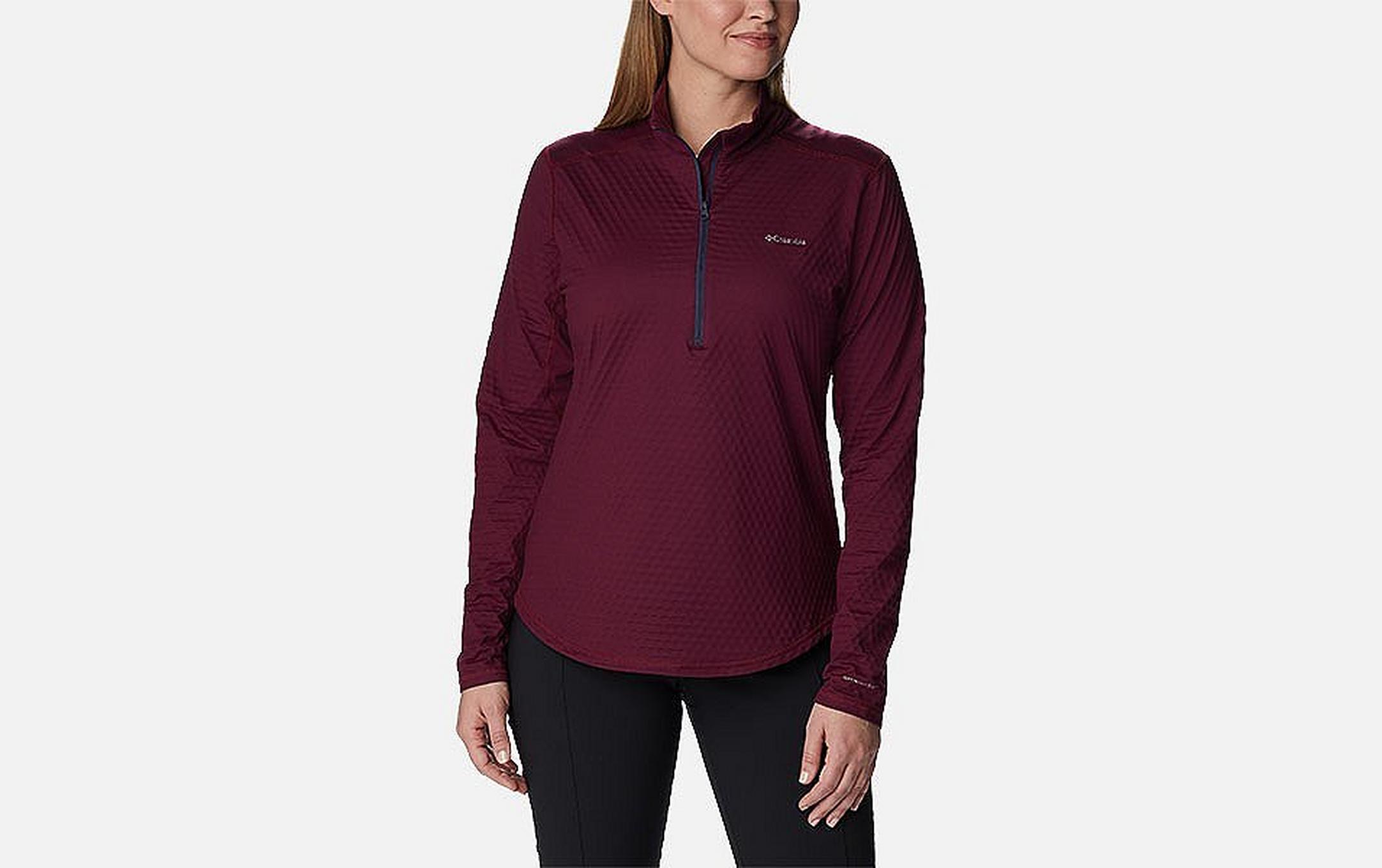 A product image of a woman wearing Columbia Sportswear’s Bliss Ascent Half Zip Shirt against a white background.