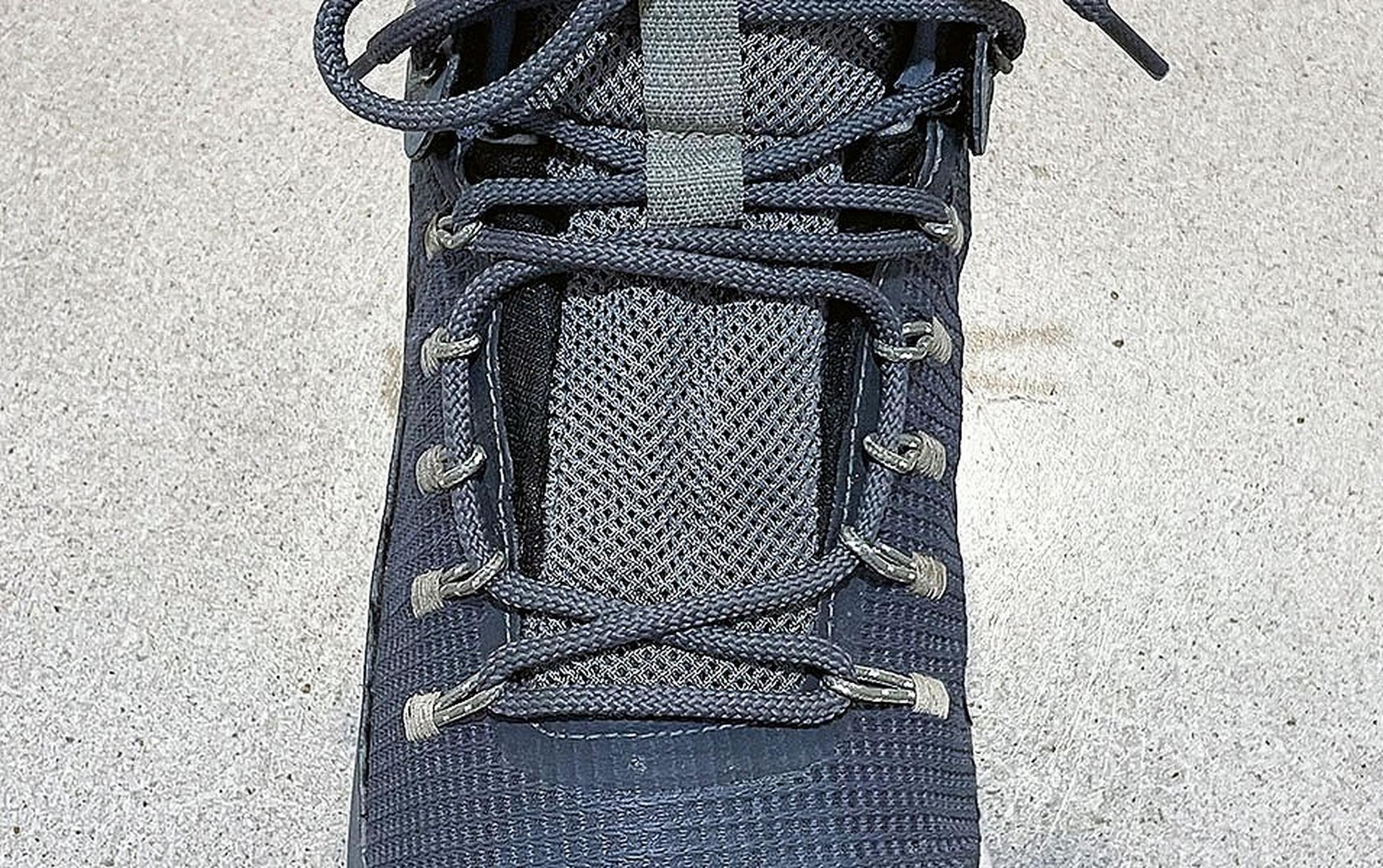 A close-up shot of a blueish-gray Columbia Sportswear hiking boot displaying window lacing.