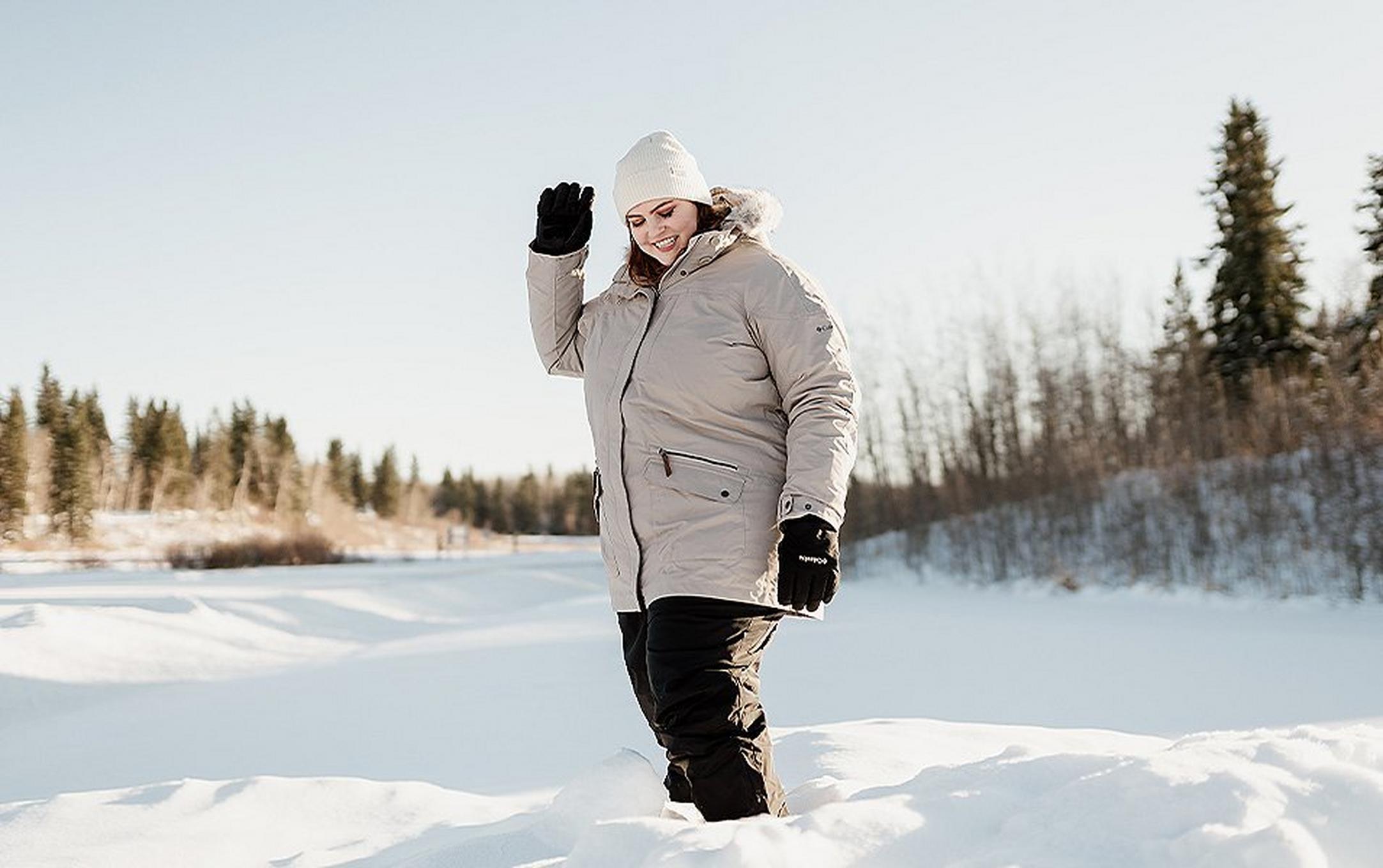 Woman standing in a snowy field.