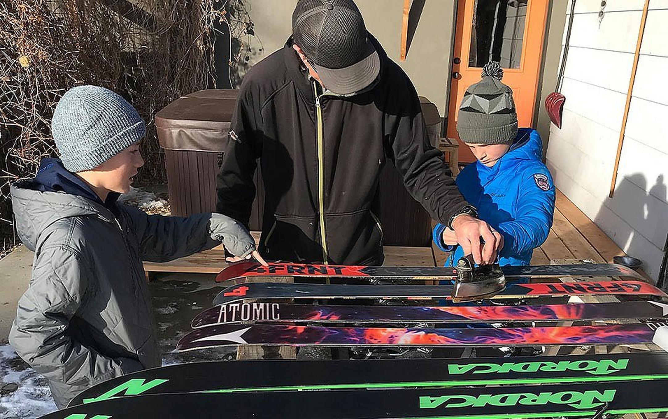 People waxing skis.