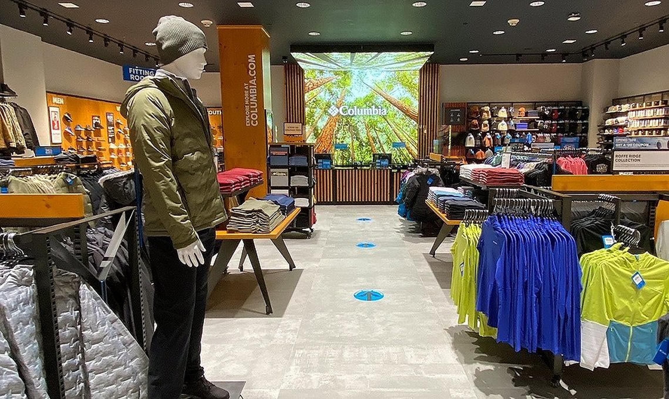 Interior of a Columbia retail space with a dressed mannequin and racks of clothes.