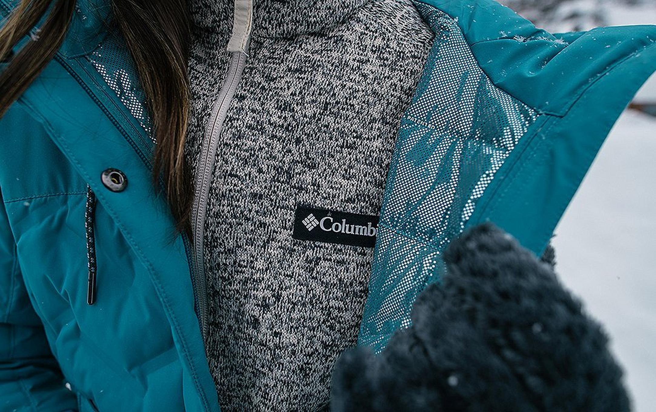 A close-up shot of a gray knit midlayer underneath a blue Columbia Sportswear jacket.