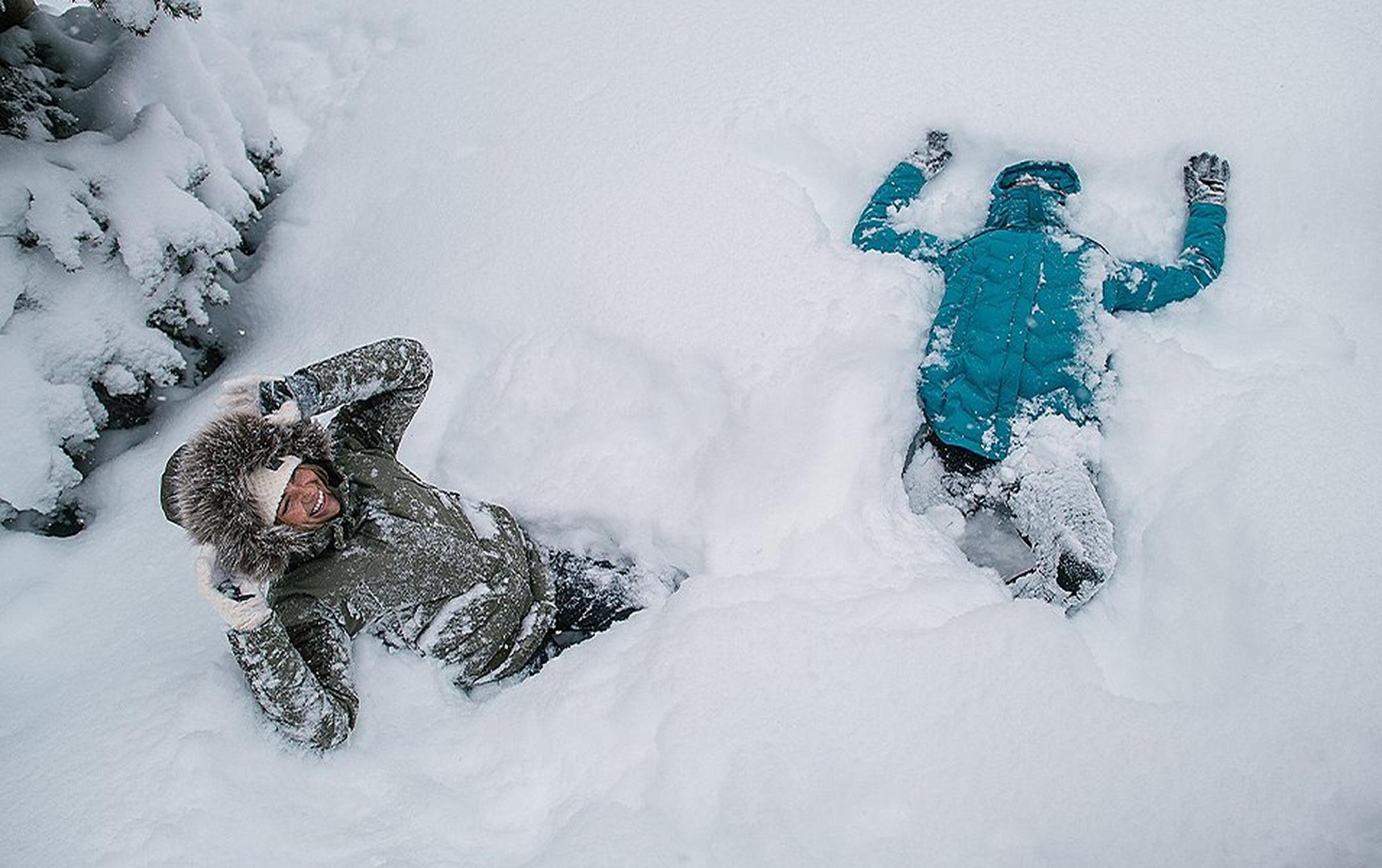 Two people playing in deep snow.