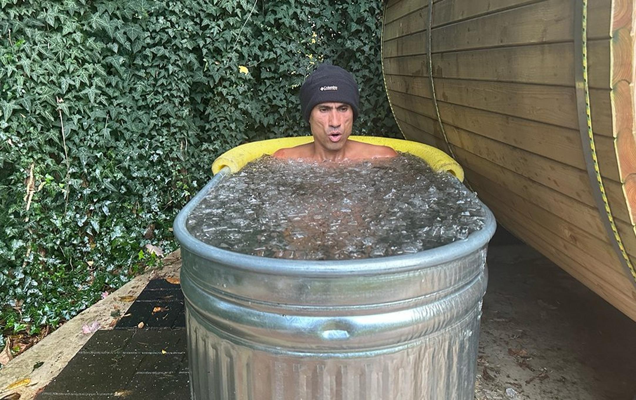Pro trail runner Yassine Diboun sits in his homemade ice bath in his backyard.
