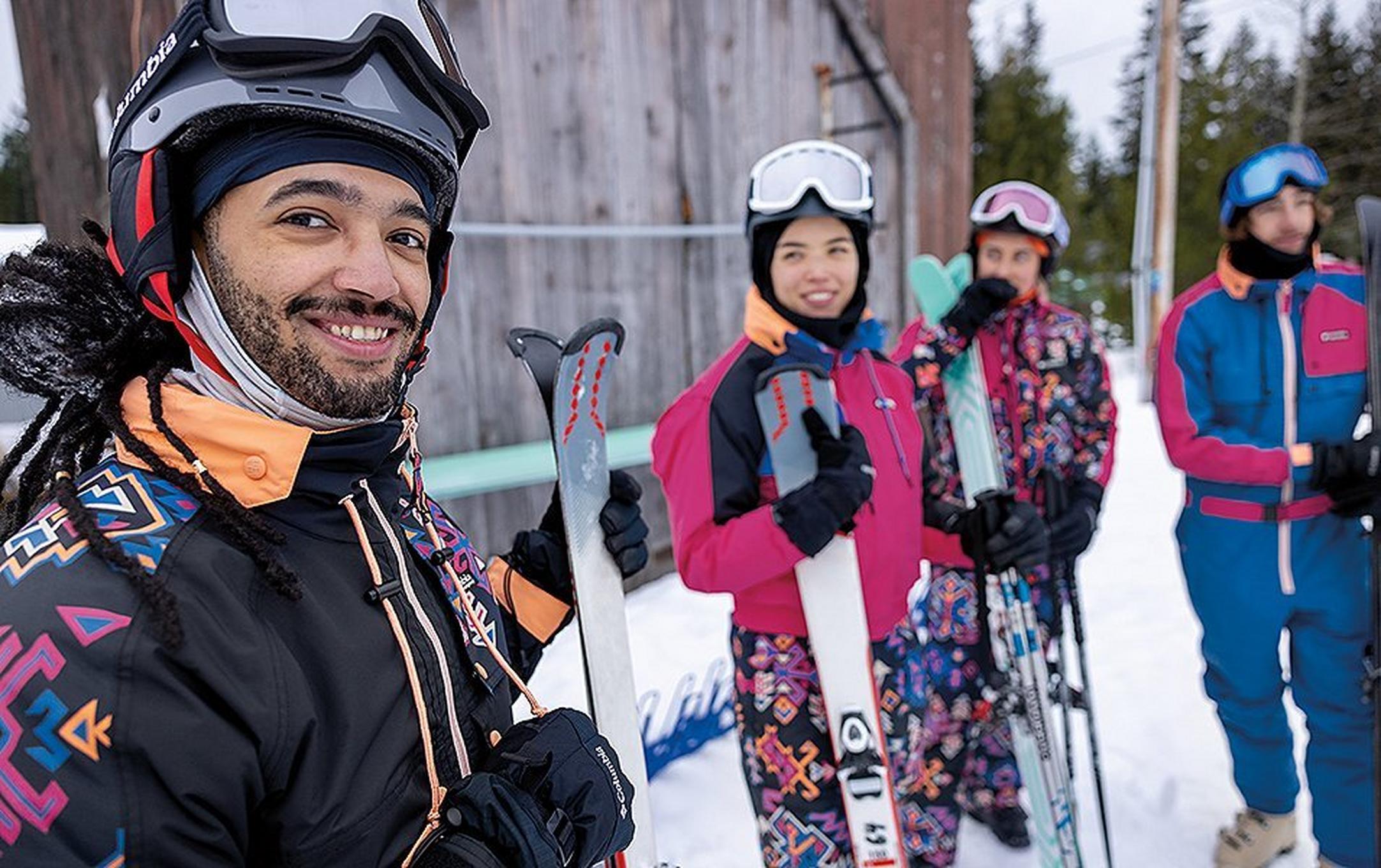 A skier looks at the camera smiling while a gorup of friends stands in the background.