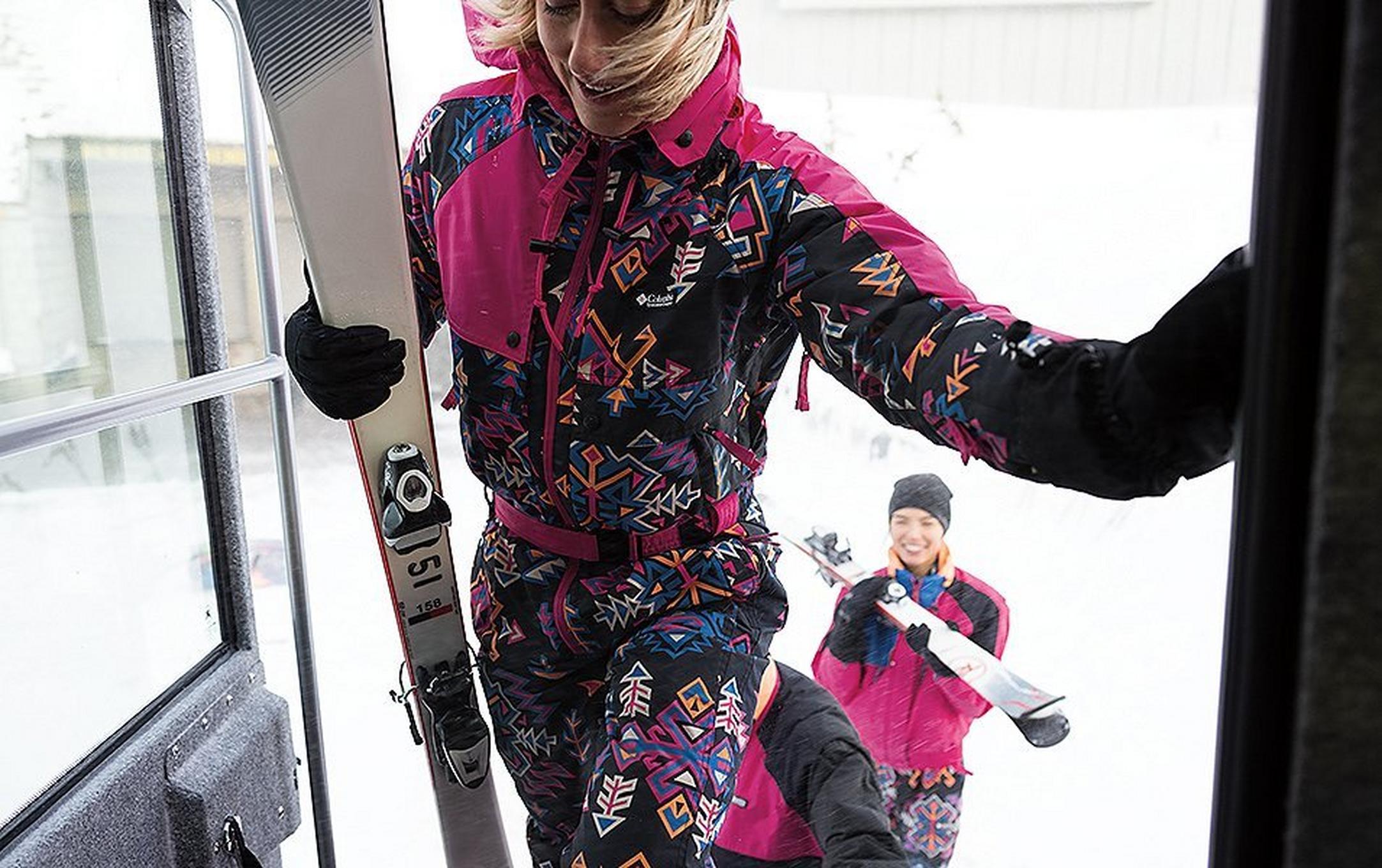 A woman in a pink retro ski suit walks onto the gondola.