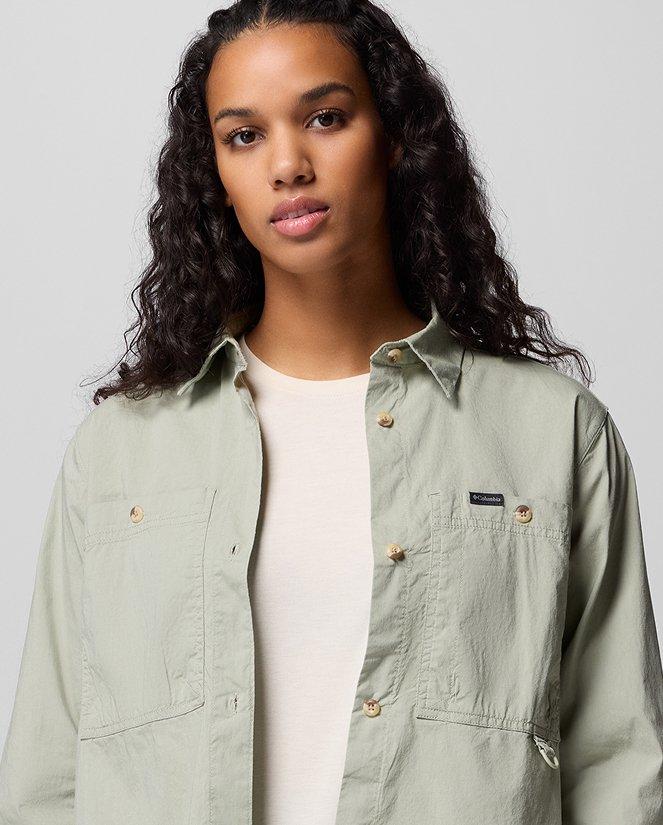 A woman wearing a light green button-up shirt.