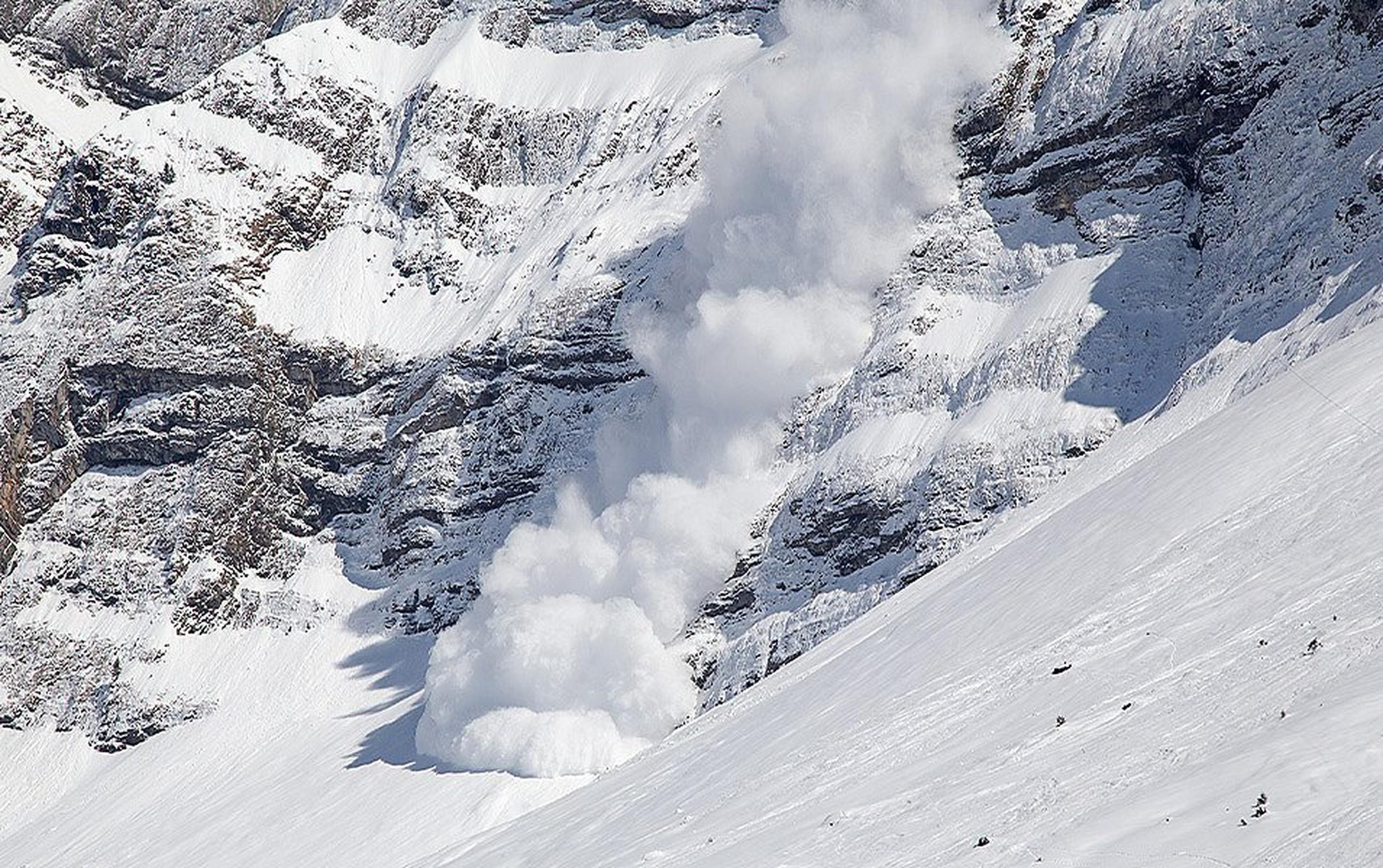 A large avalanche roars down a low angle cliff band. Fortunately, there are no people in its tracks.
