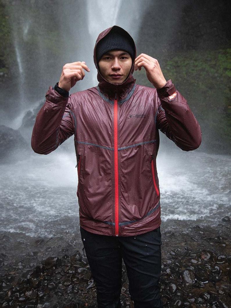 Portrait of man standing next to a waterfall.