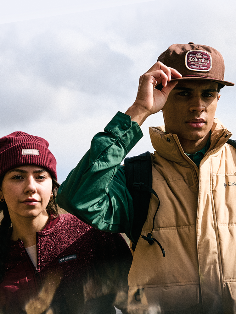 Man with a brown had and windbreaker, women in the background with beanie