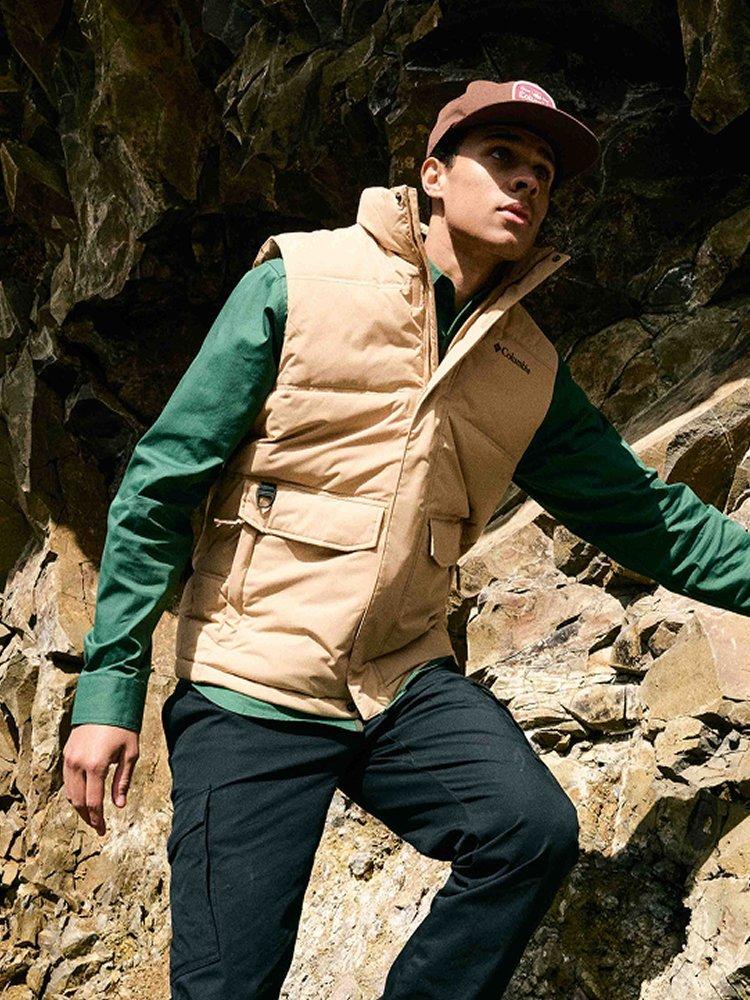 Man with a brown had and windbreaker, women in the background with beanie