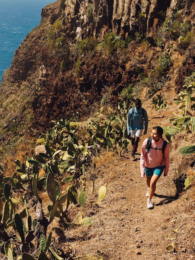 Two people walking on a desert trail.