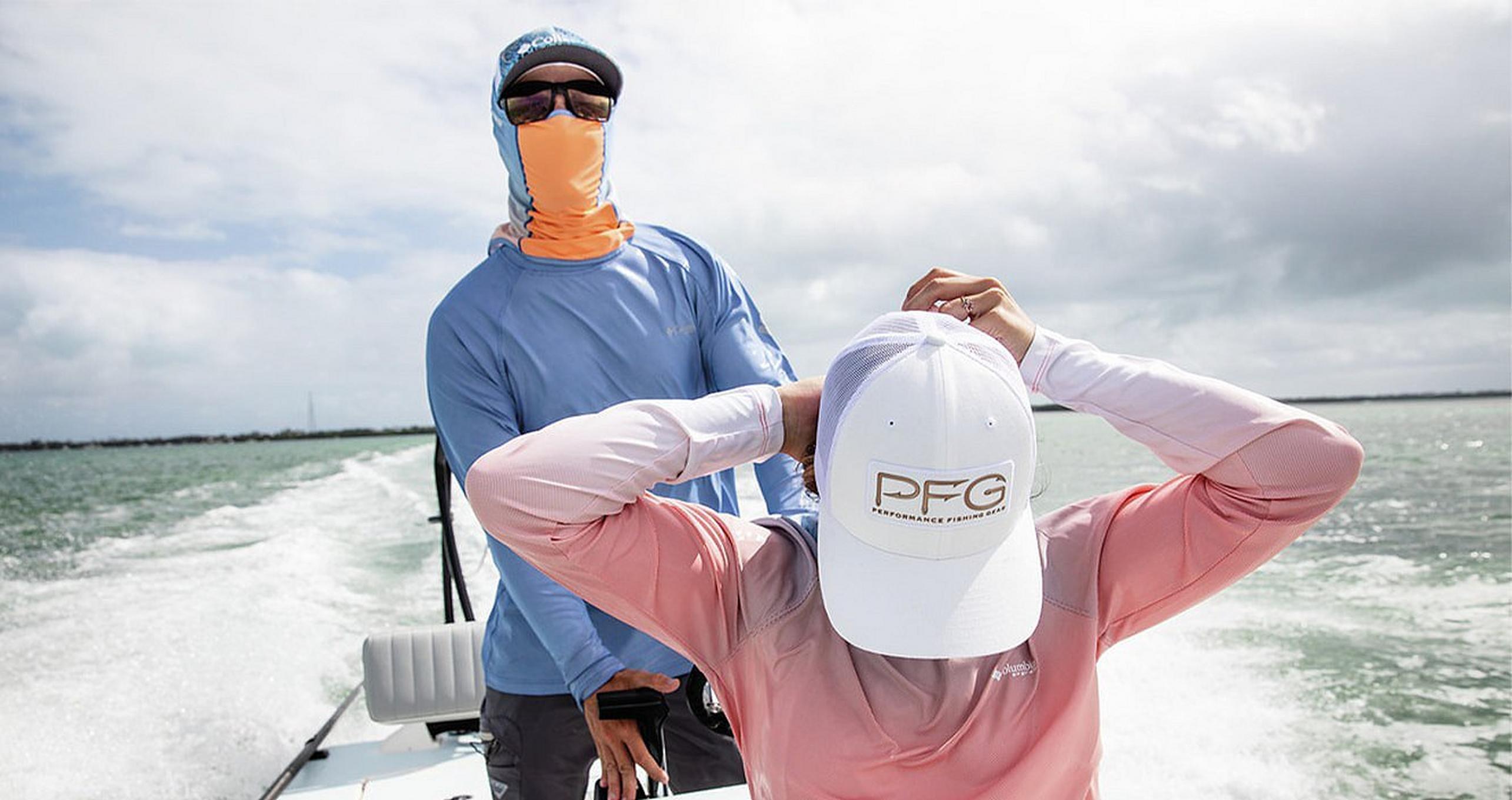 Two people in sun protected gear riding in a boat in the ocean.