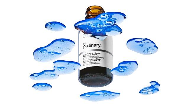 The Ordinary Multi-Peptide + Copper Peptides 1% Serum bottle with blue Multi-Peptide + Copper Peptides 1% Serum swatches around the bottle