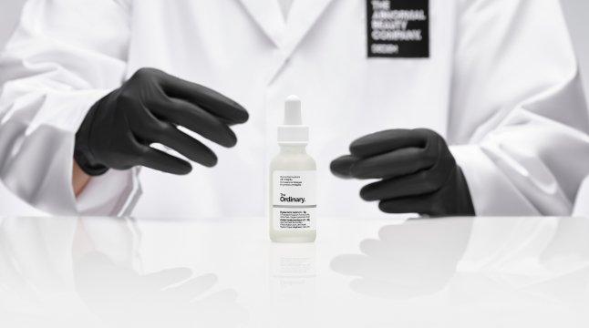 The Ordinary scientist handling a The Ordinary serum bottle