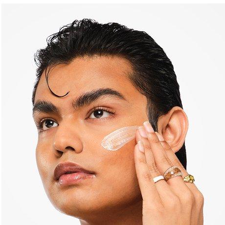 Model applying UV Filters SPF 45 Serum to their cheek