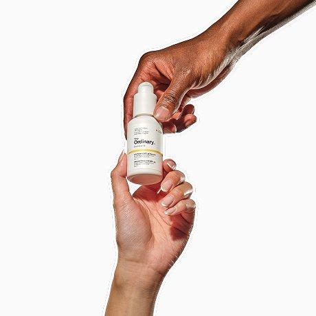 Two hands exchanging The Ordinary UV Filters SPF 45 Serum.