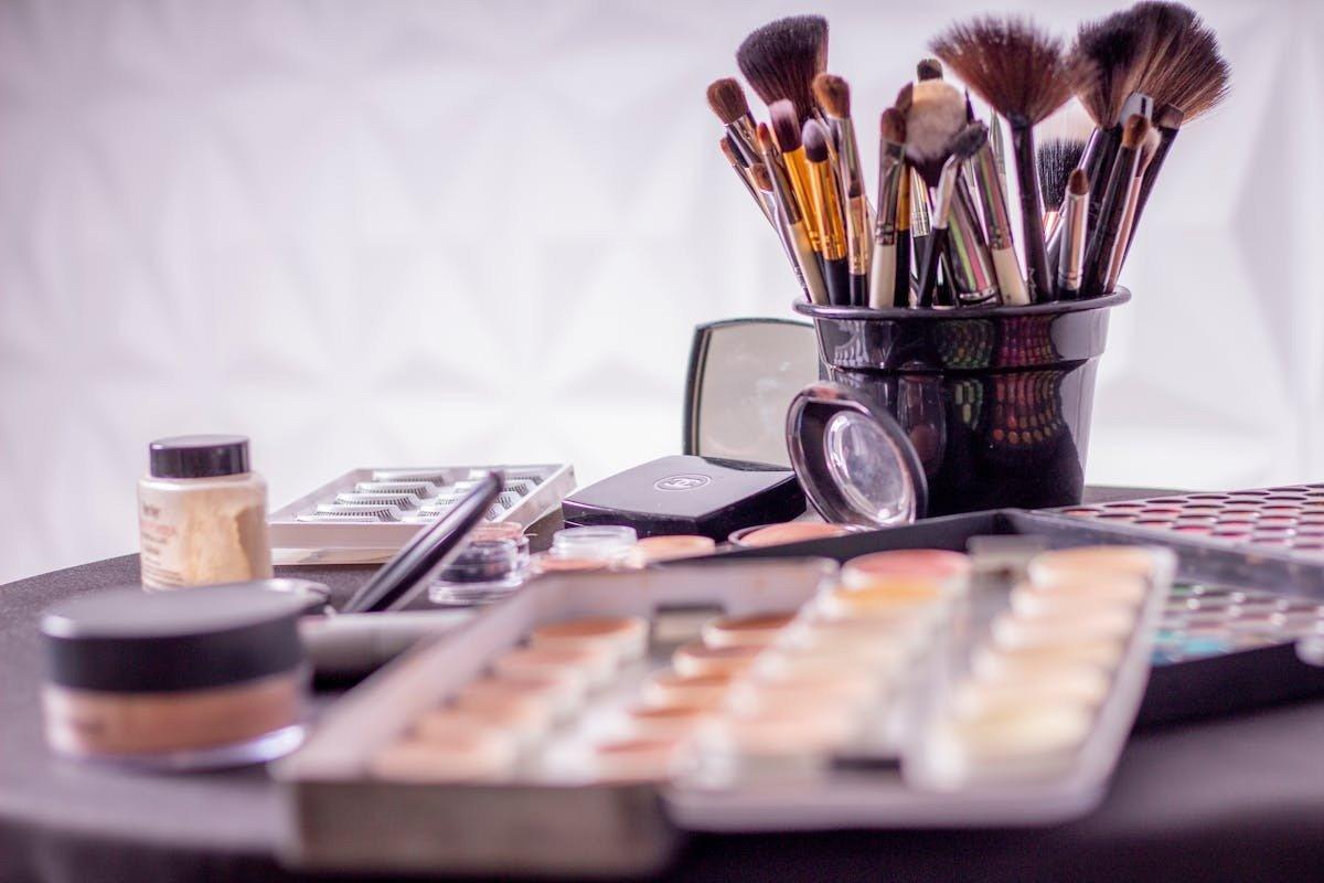 a table with a bunch of makeup brushes and makeup on it