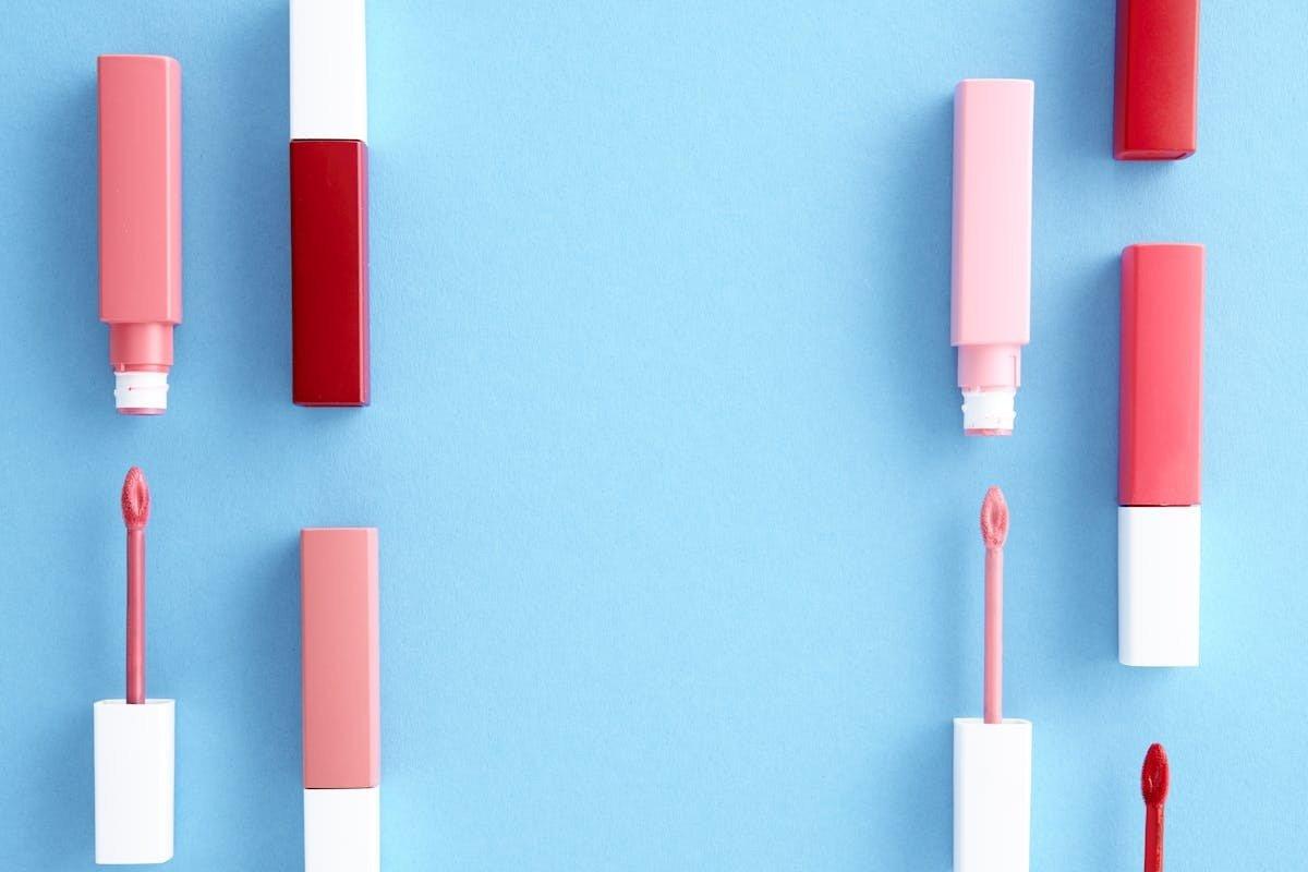 lipstick tubes on a blue background with a red lipstick