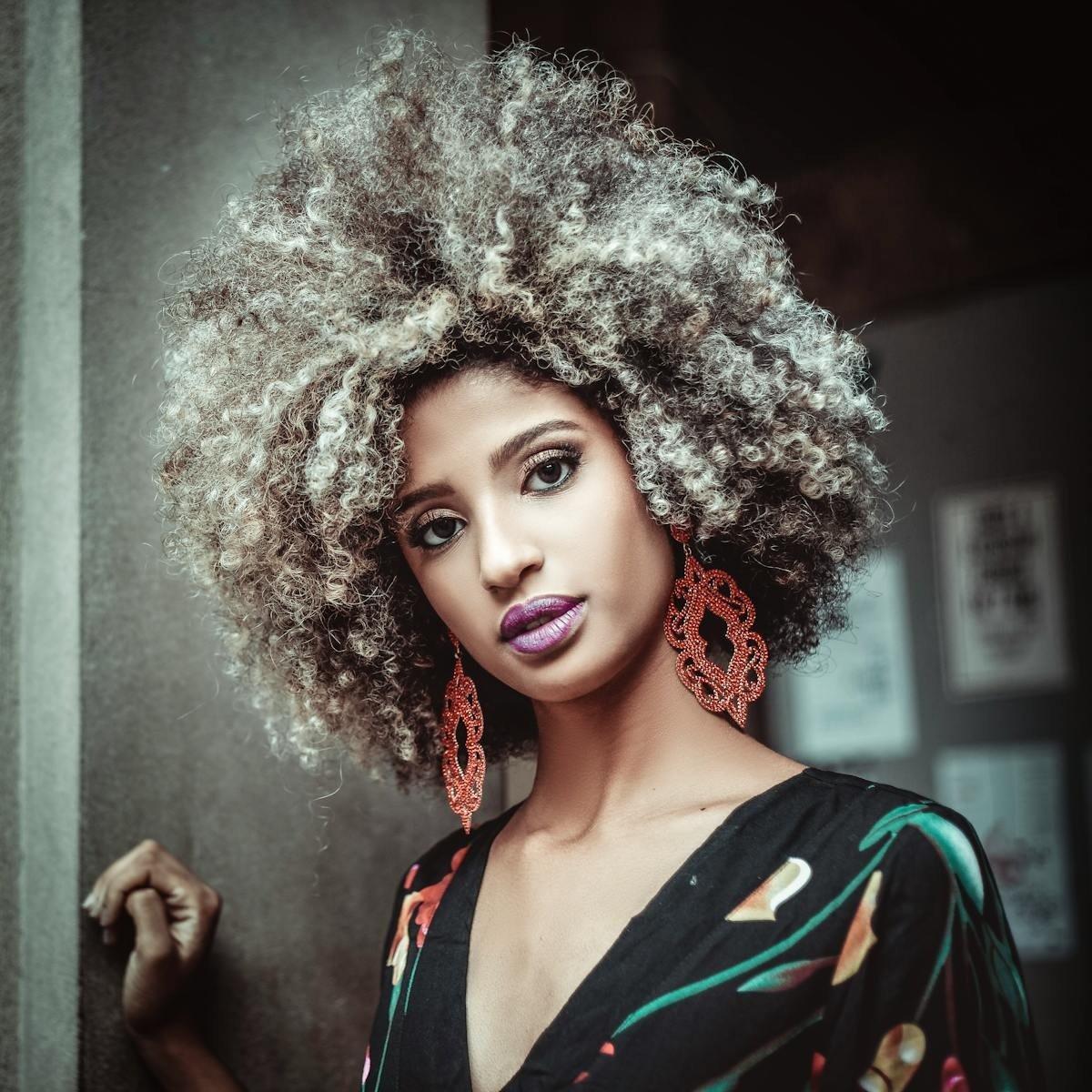 a woman with a big afro and purple lips