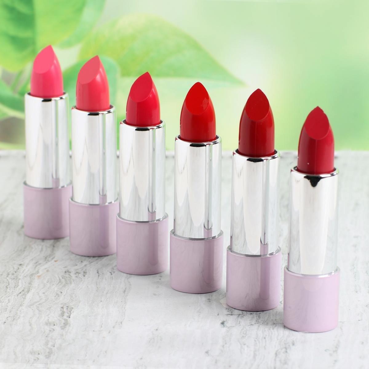 a row of five red lipstick in a row on a table