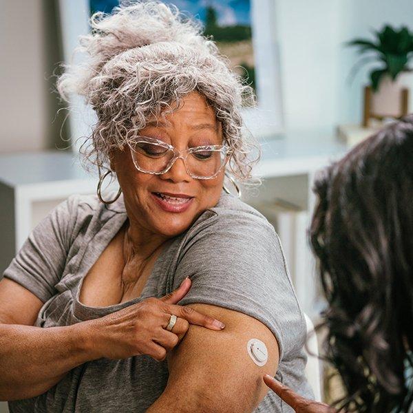 Dexcom G7 user receiving assistance from a health care professional.