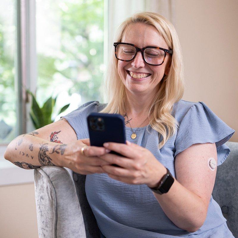 Dexcom G7 user checking Clarity reports on her smart phone.