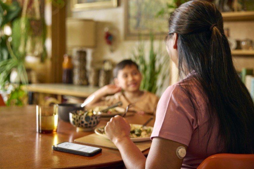 Family eating a meal, with mom wearing a Dexcom G7.