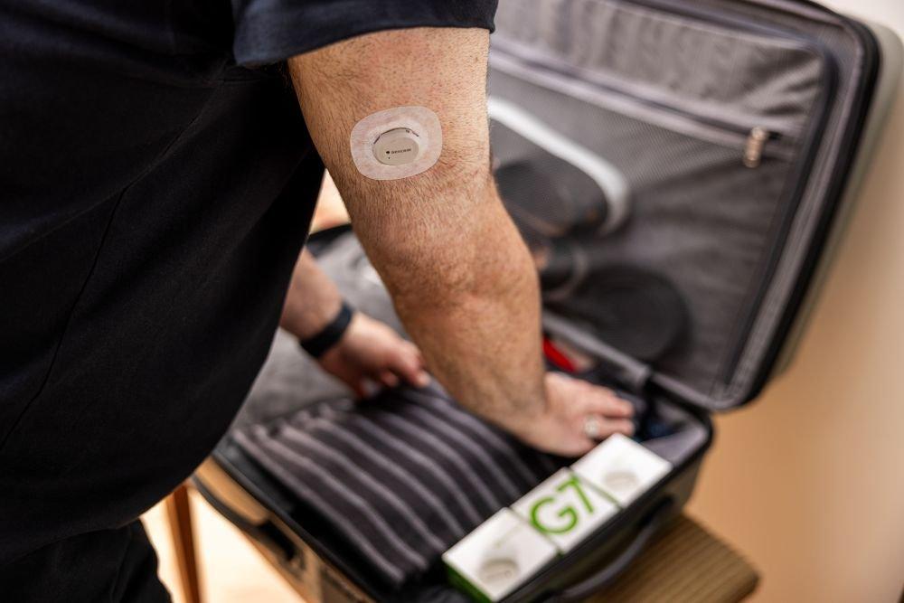 Dean wearing sensor on his arm and packing his suitcase