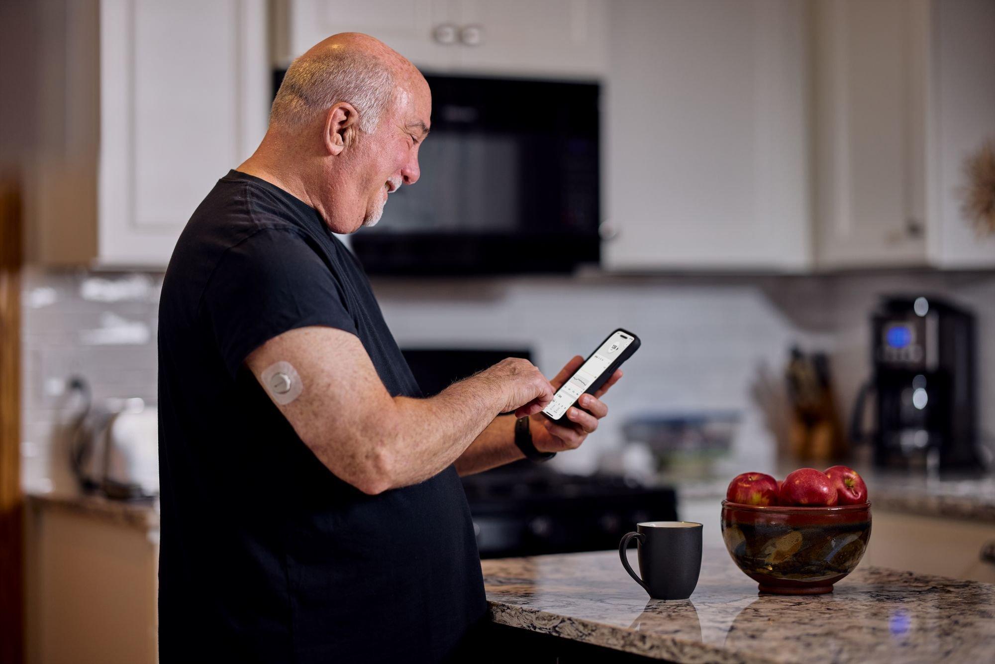 Dean on his phone in the kitchen